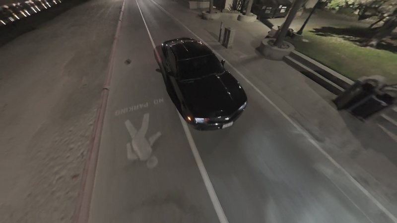 Night FPV chase alongside a black Mustang on a beachfront street